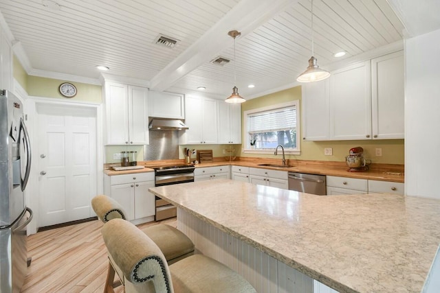 kitchen with pendant lighting, sink, stainless steel appliances, a kitchen breakfast bar, and white cabinets