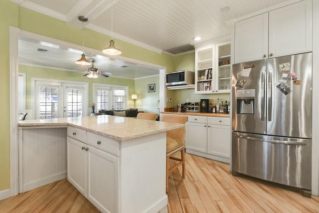 kitchen with appliances with stainless steel finishes, french doors, white cabinets, light stone countertops, and light hardwood / wood-style flooring