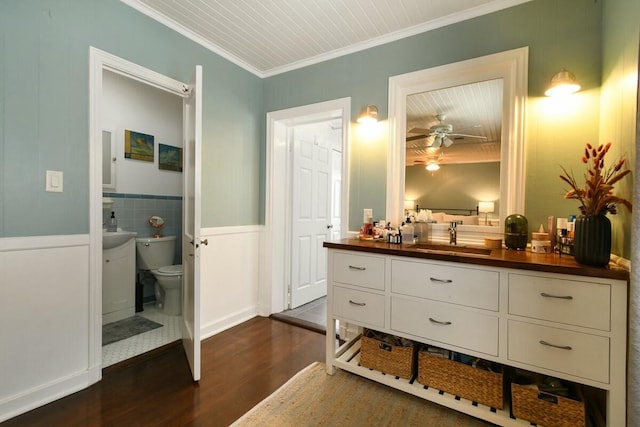 bathroom featuring toilet, crown molding, vanity, ceiling fan, and hardwood / wood-style floors