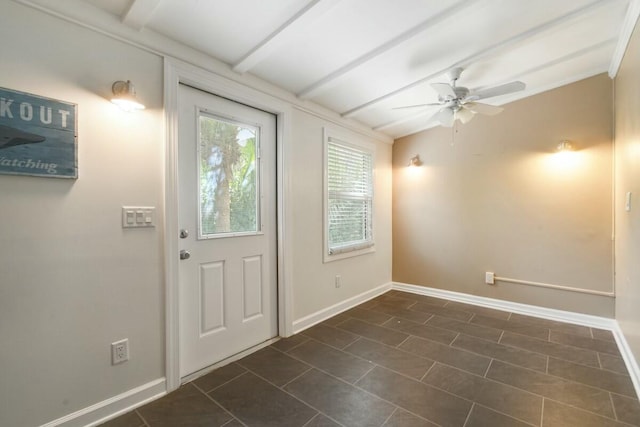 doorway featuring beamed ceiling, ceiling fan, and dark tile patterned flooring