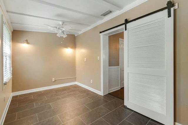 empty room with a barn door and ceiling fan