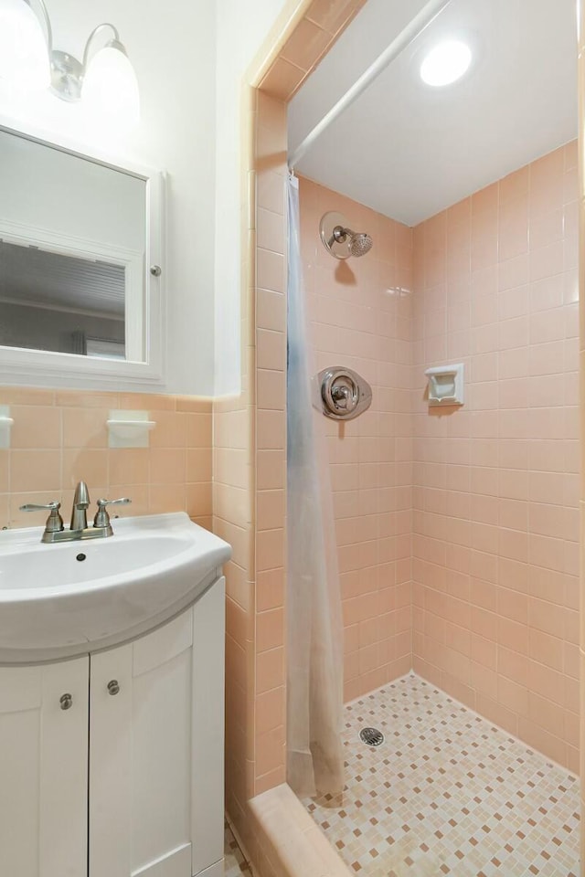 bathroom with vanity, tile walls, and walk in shower