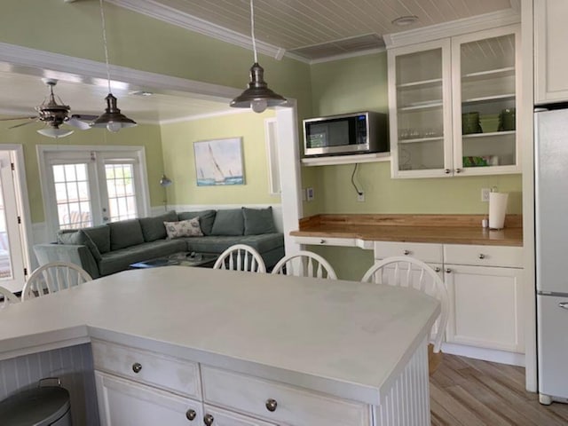 kitchen with white cabinets, hanging light fixtures, and white refrigerator