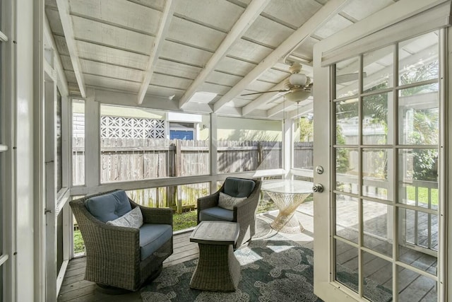 sunroom / solarium featuring ceiling fan and beam ceiling