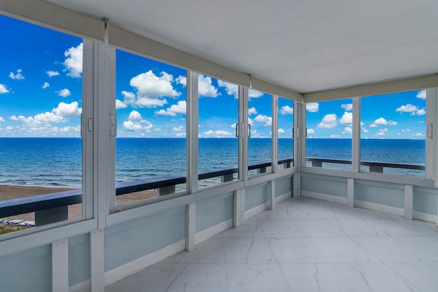 sunroom featuring a healthy amount of sunlight and a water view