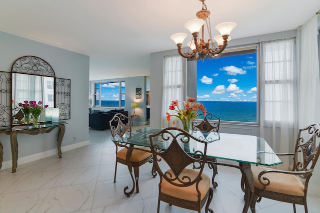 dining room with a notable chandelier and a water view