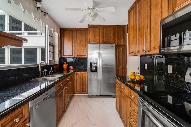 kitchen with decorative backsplash, dark stone countertops, sink, appliances with stainless steel finishes, and ceiling fan