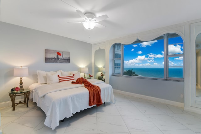 bedroom featuring a water view and ceiling fan