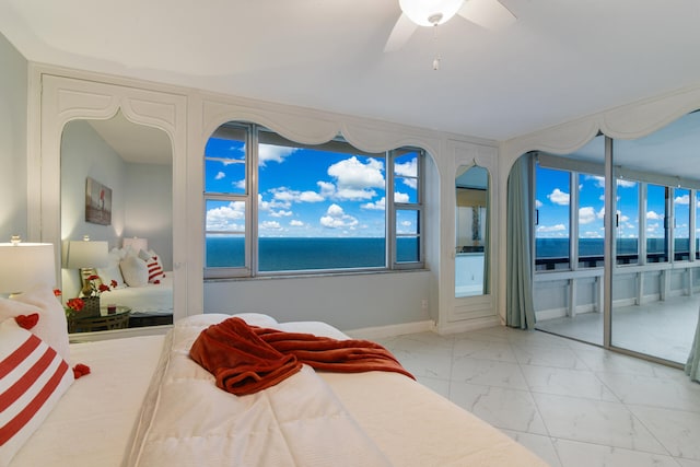 bedroom with a water view and ceiling fan