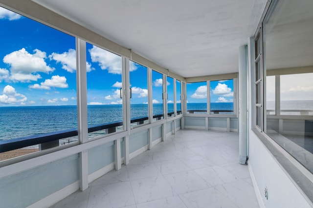 sunroom featuring a wealth of natural light and a water view