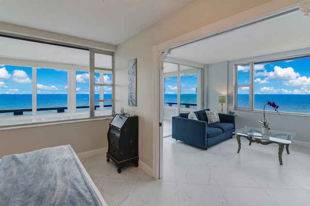 living room featuring a water view, a wealth of natural light, and a beach view