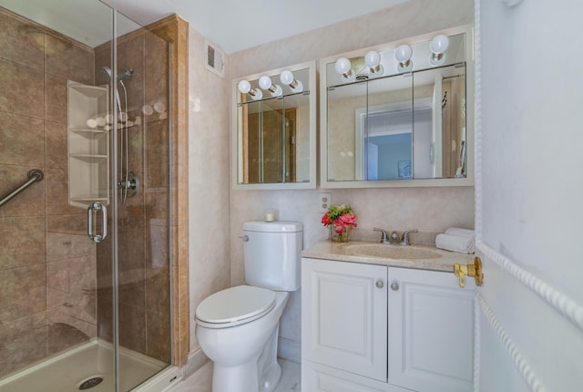 bathroom featuring vanity, a shower with shower door, and toilet