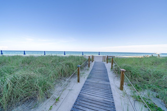 dock area with a water view and a view of the beach