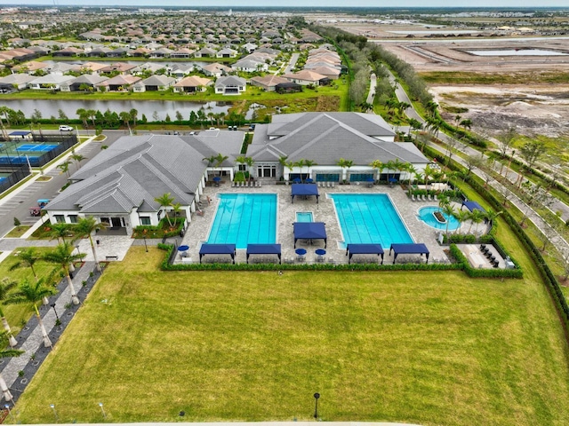 view of swimming pool featuring a water view, a lawn, and a patio