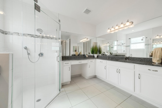 bathroom with tile patterned flooring, vanity, and a shower with door