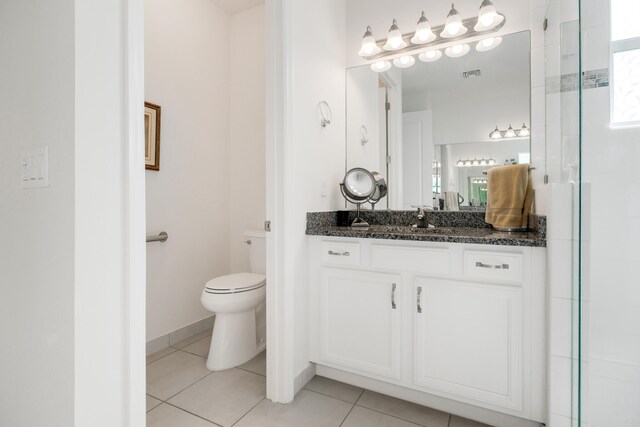 bathroom featuring walk in shower, tile patterned flooring, vanity, and toilet