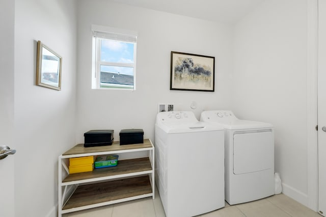 washroom with washing machine and clothes dryer and light tile patterned flooring