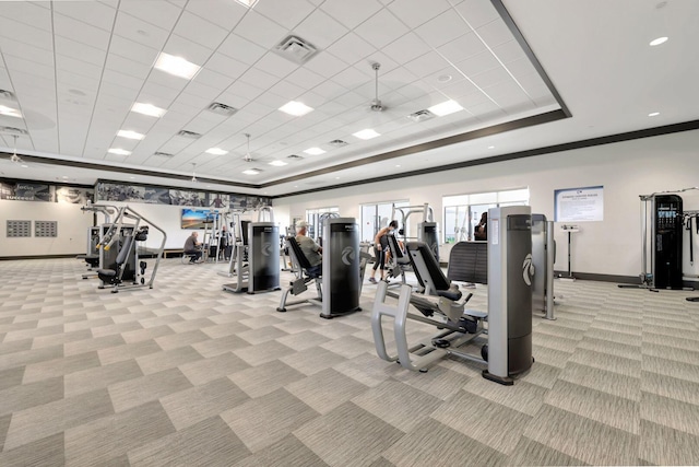 exercise room with light colored carpet, a paneled ceiling, and a tray ceiling