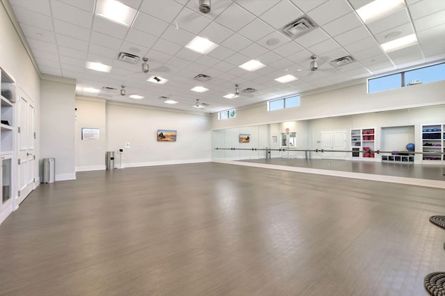 interior space featuring a drop ceiling, hardwood / wood-style floors, and a high ceiling