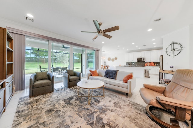 living room featuring ornamental molding, a healthy amount of sunlight, ceiling fan, and light tile patterned flooring