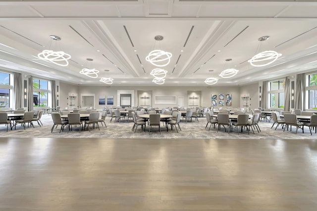 unfurnished dining area featuring a tray ceiling, a healthy amount of sunlight, and light hardwood / wood-style flooring