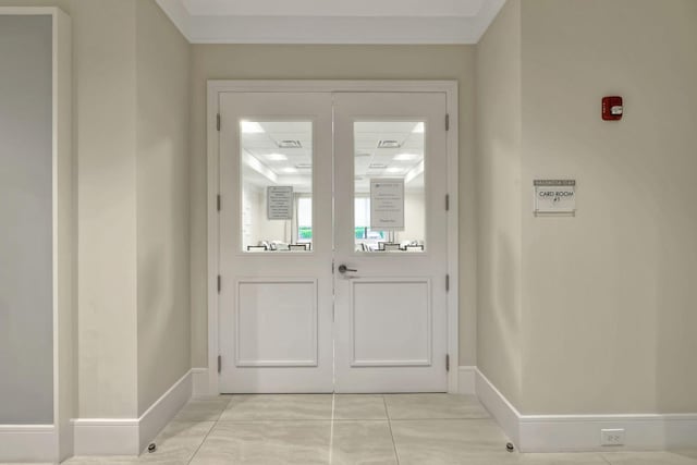 entryway with light tile patterned floors and crown molding