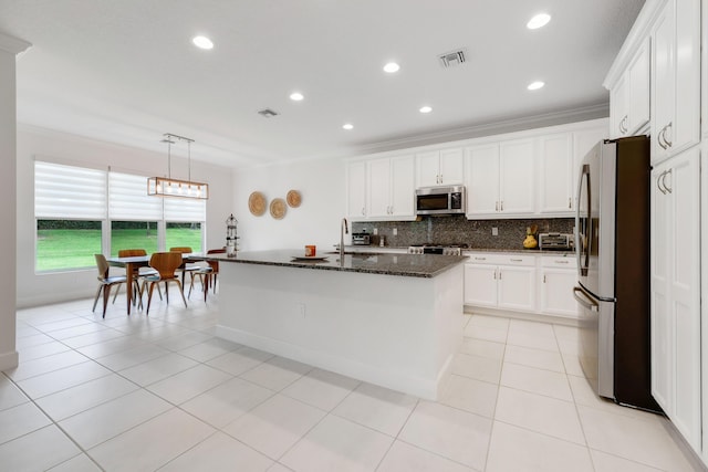 11762 SW Waterford Isle Way, Port Saint Lucie, FL 34987 - kitchen featuring stainless steel appliances, ornamental molding, dark stone counters, tasteful backsplash, and white cabinets