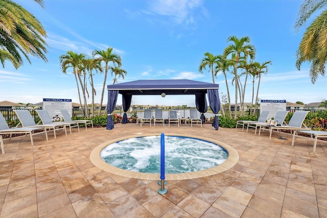 view of swimming pool with a patio area, a community hot tub, and a gazebo