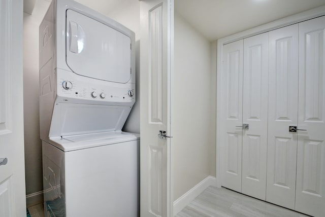 laundry room featuring stacked washing maching and dryer and light wood-type flooring