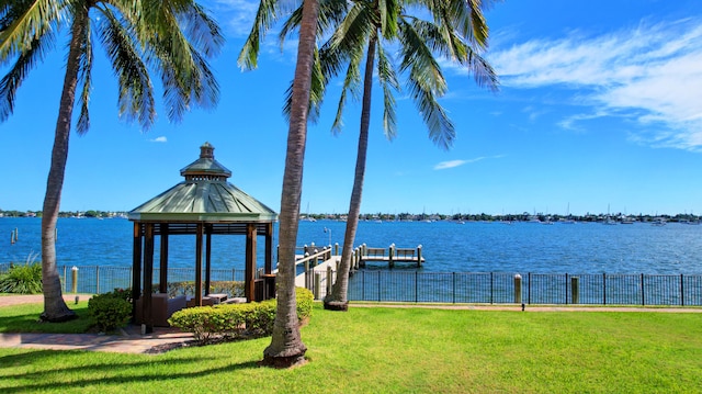 view of dock featuring a water view, a gazebo, and a lawn