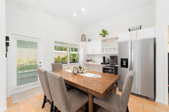 tiled dining room featuring high vaulted ceiling