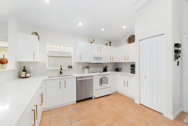 kitchen with white cabinetry, appliances with stainless steel finishes, sink, and vaulted ceiling