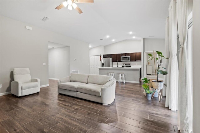 living room with lofted ceiling, dark wood-type flooring, and ceiling fan