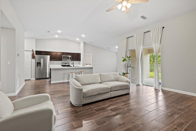 living room with lofted ceiling, dark hardwood / wood-style floors, and ceiling fan