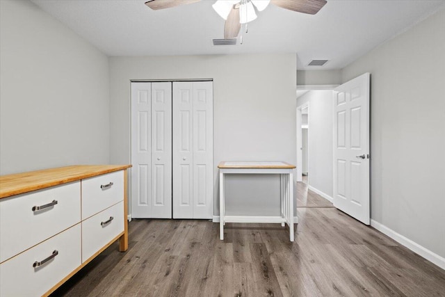 unfurnished bedroom with wood-type flooring, a closet, and ceiling fan