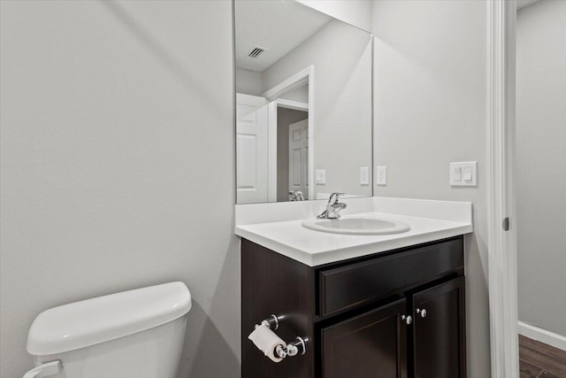 bathroom featuring vanity, toilet, and hardwood / wood-style flooring