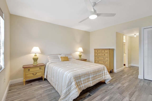 bedroom featuring a closet, light hardwood / wood-style floors, ceiling fan, and connected bathroom