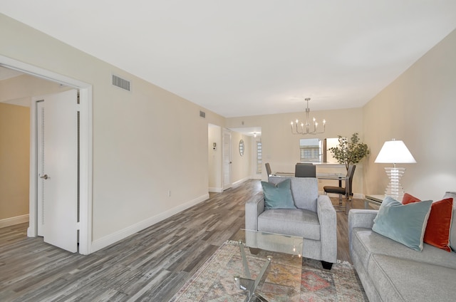 living room with hardwood / wood-style floors and a notable chandelier