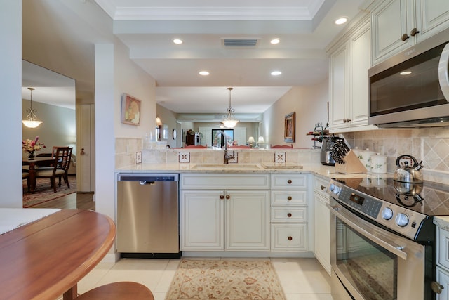 kitchen with kitchen peninsula, appliances with stainless steel finishes, sink, and ornamental molding