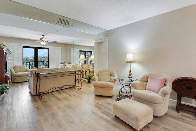 living room featuring light wood-type flooring and ceiling fan