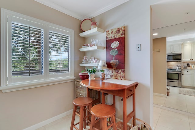 dining room featuring light tile patterned floors and crown molding