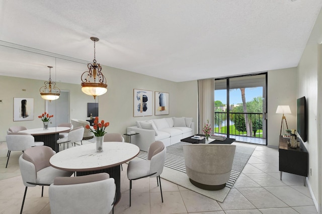 living room featuring a textured ceiling, light tile patterned floors, and a wall of windows