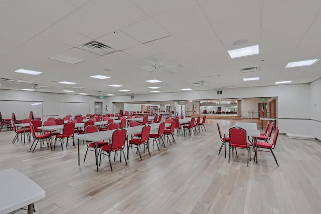 dining area featuring light hardwood / wood-style floors and a drop ceiling