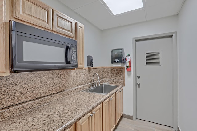 kitchen featuring decorative backsplash, sink, and light brown cabinetry