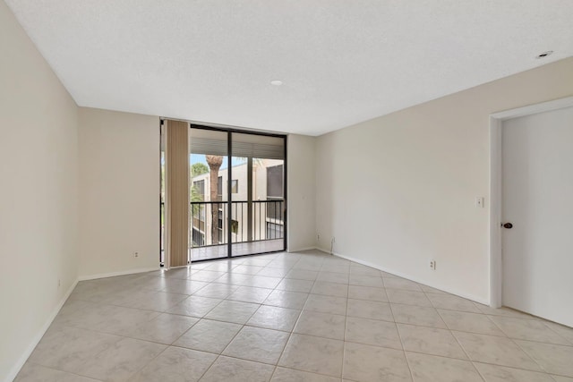 tiled spare room with a wall of windows