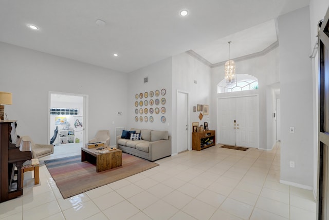 tiled living room with a notable chandelier, a towering ceiling, and ornamental molding