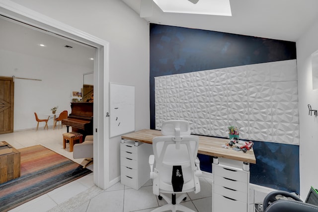 office area with a barn door and light tile patterned flooring