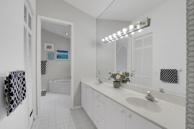 bathroom with vanity, vaulted ceiling, tile patterned floors, and a bathing tub