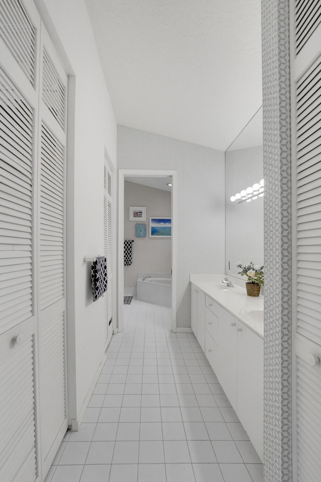 bathroom with vanity, lofted ceiling, and tile patterned floors