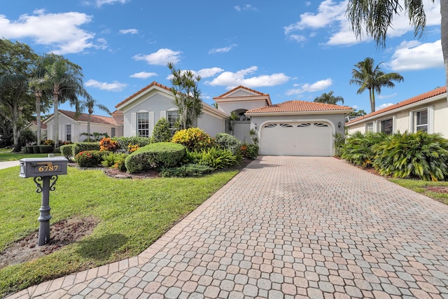 mediterranean / spanish house featuring a front lawn and a garage